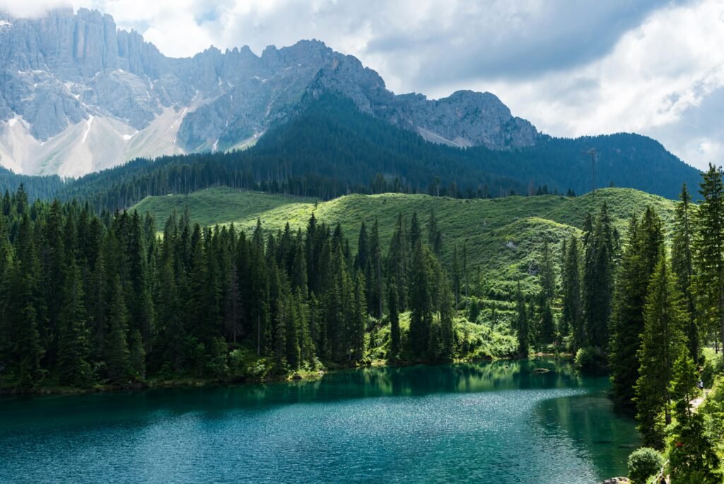Breathtaking landscape of Lago di Carezza with lush forests and Dolomites in Italy.