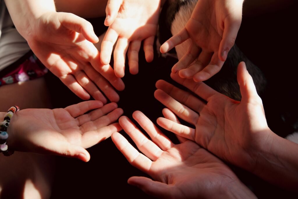 A close-up of diverse hands in a circle symbolizes unity and teamwork.